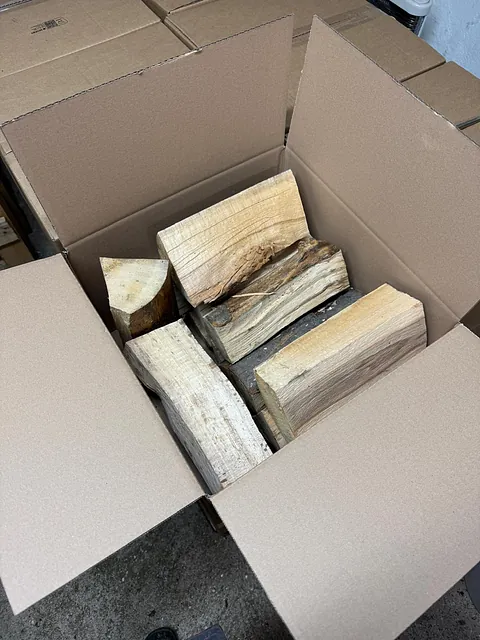 Eine Kiste voller Holzstücke steht auf einem Tisch.