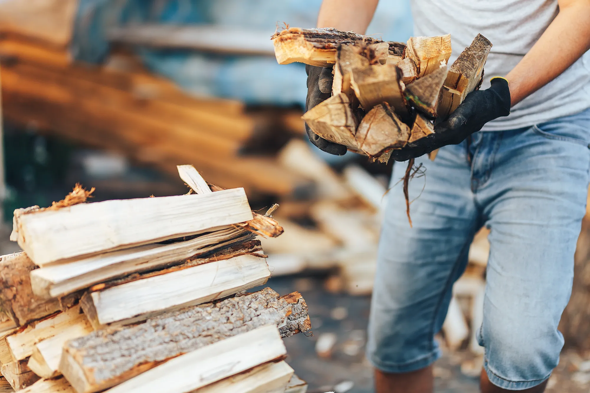 Ein Mann hält einen Stapel Holz in seinen Händen.